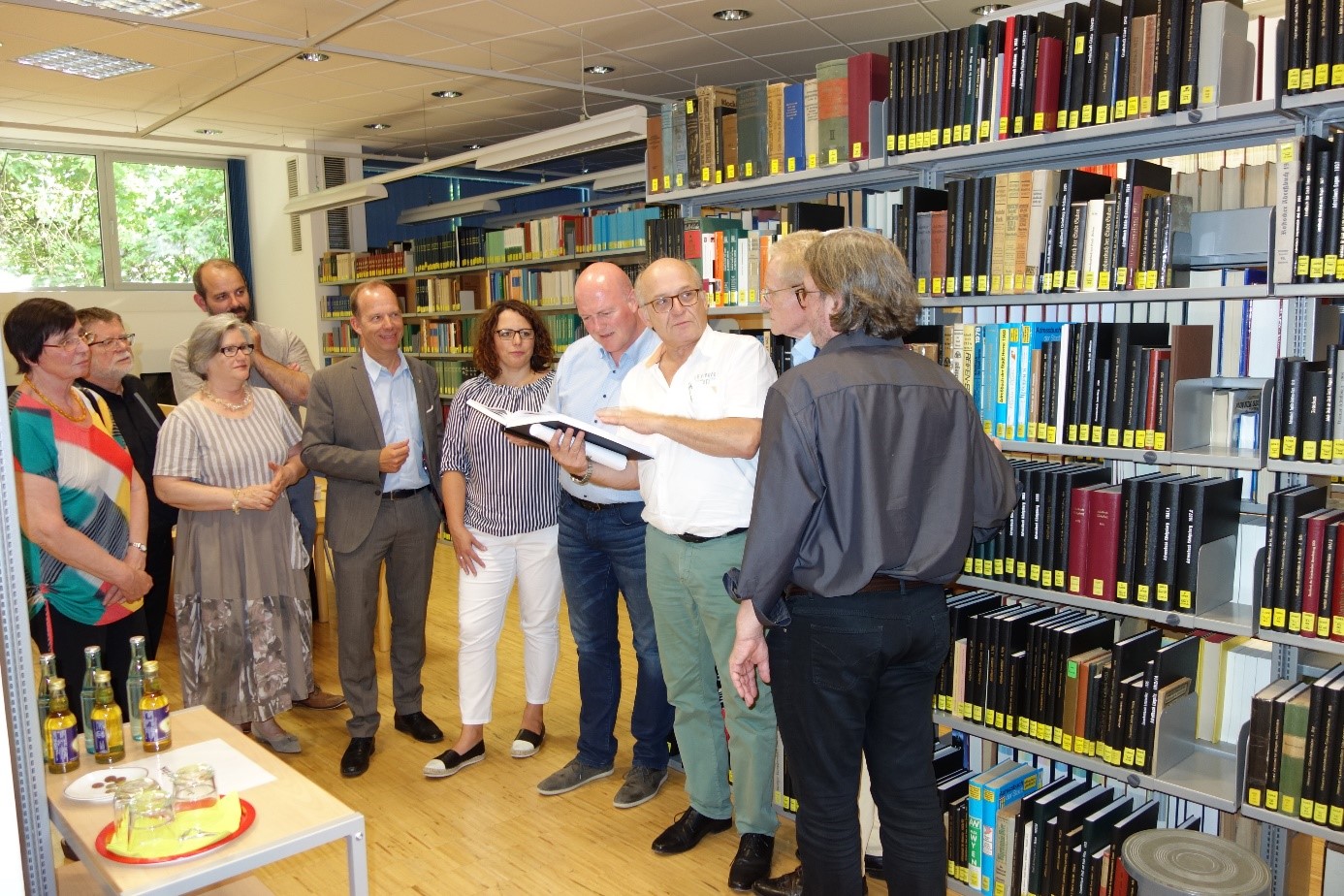 Dr. Hans-Jakob Tebarth zeigt den Sitzungsteilnehmenden die Martin-Opitz-Bibliothek