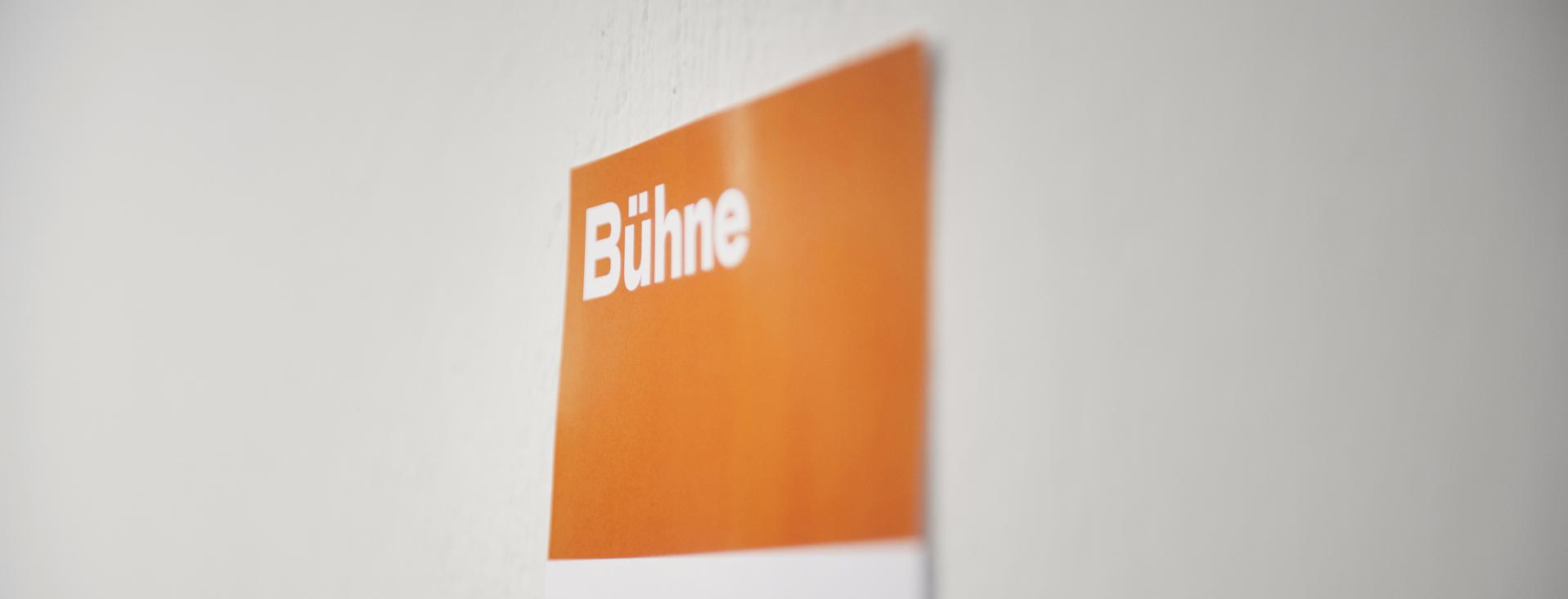 Orangenes Wandschild mit der Aufschrift "Bühne"