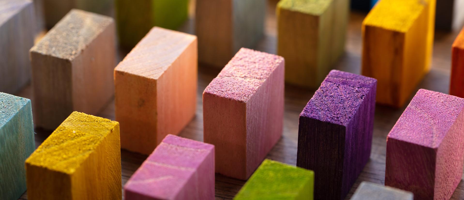 Bunte Holz-Klötzchen in Reihen aufgestellt