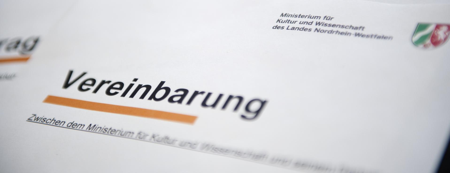 Auf einem Blatt mit dem Logo des Ministeriums steht das Wort Vereinbarung